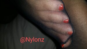 Black nylon pantyhose toes with red nail polish