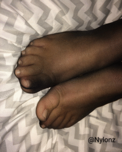 Black nylon pantyhose feet with nude toe nail polish